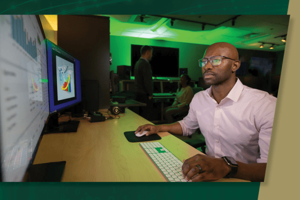 Man working at a desk as part of the Charlotte's Online MBA program