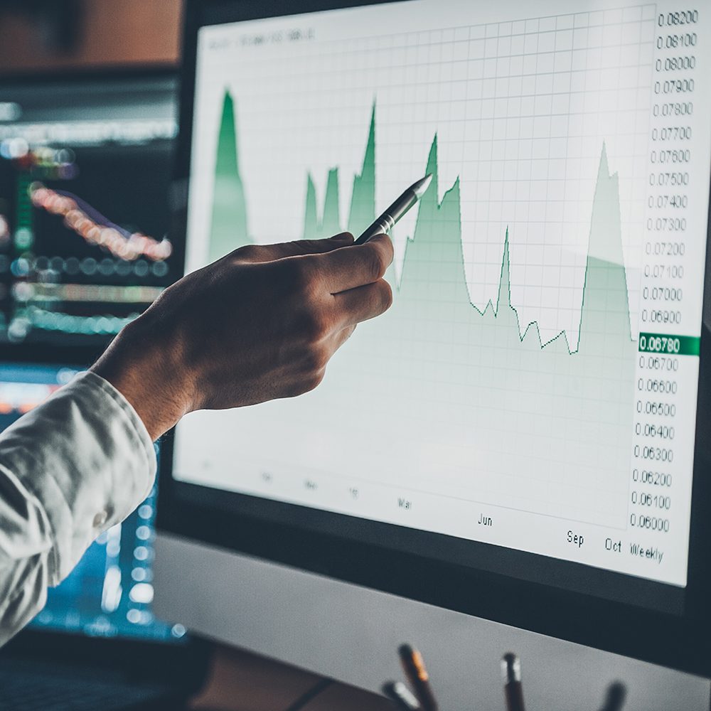 Finance; Analyzing data. Close-up of young businessman pointing on the data presented in the chart with pen while working in creative office