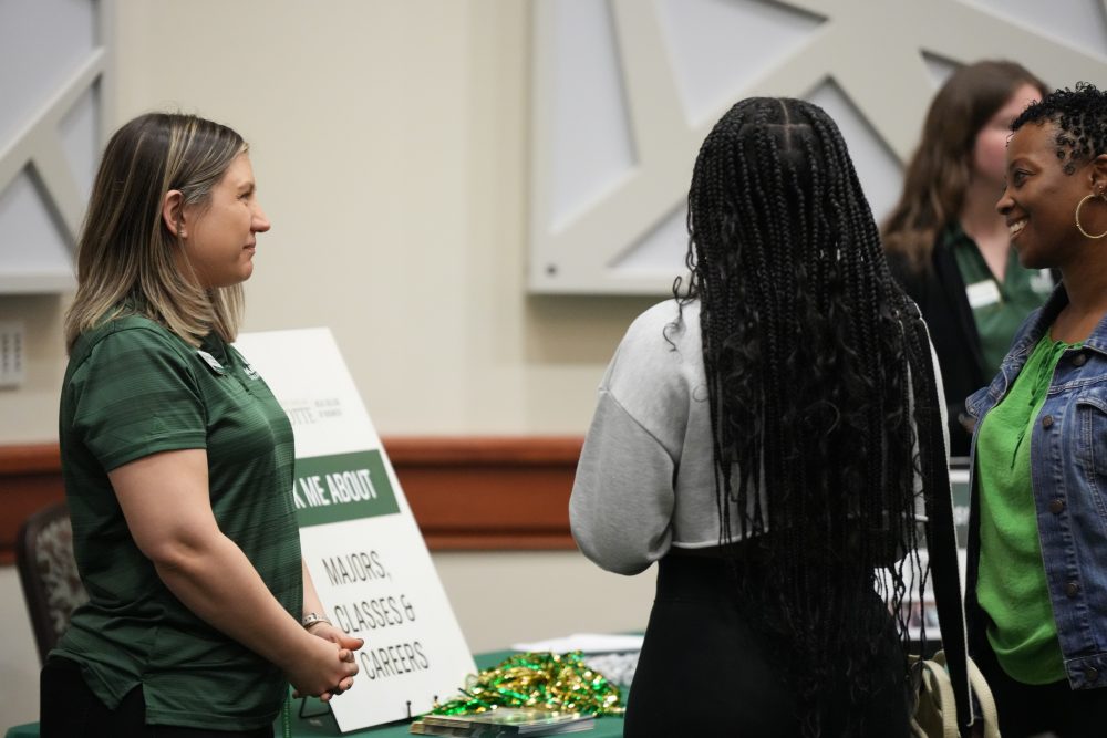 Students talking to a Niblock Student Center advisor at an event 