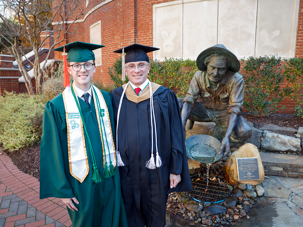 Scott Jr and Sr in front of the Niner Miner statue in their regalia