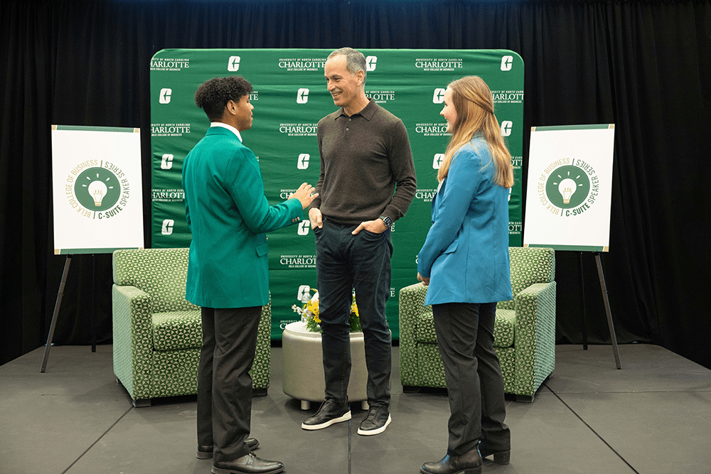 Belk Scholar Mackenzie Aarsen and Niblock Scholar Amorion Armstrong interact with Ric Elias after asking him questions submitted by Charlotte students. Both are Business Honors students. 