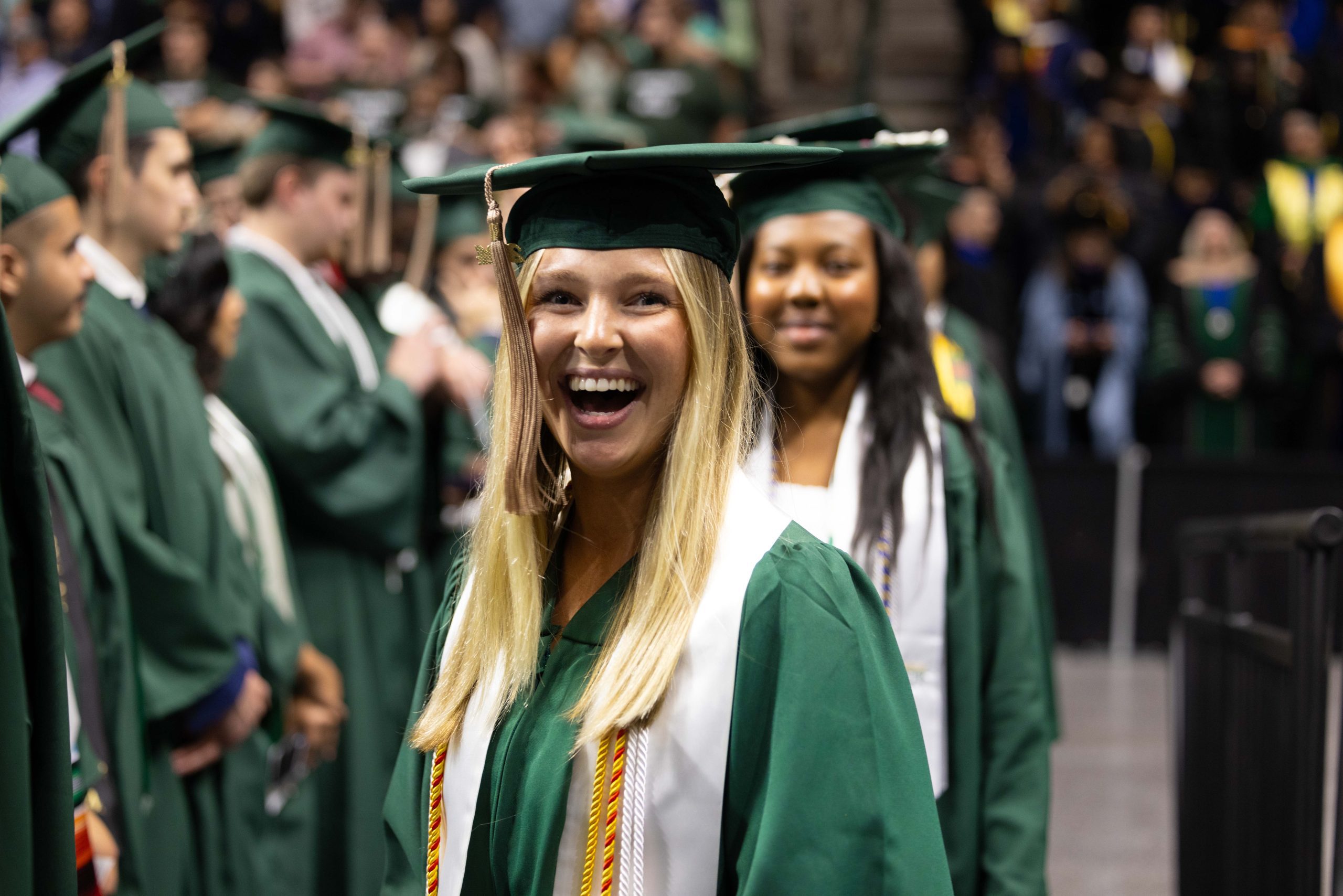 Belk College of Business Commencement with two smiling young women and the words "Gold Standard" on top