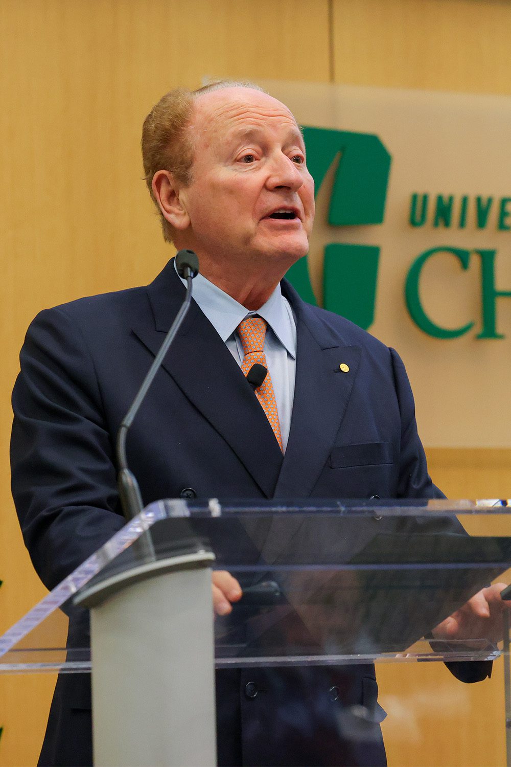 Professor Robert C. Merton speaks at a podium during the Mathematical Finance 20th anniversary event at The Dubois Center at UNC Charlotte Center City.