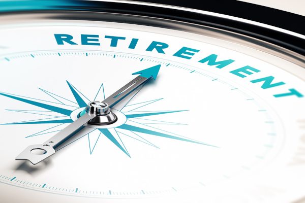 A close-up of a compass with the needle pointing toward the word "RETIREMENT" at the top. The compass rose features blue and white tones with metallic accents, symbolizing direction and guidance toward retirement planning.