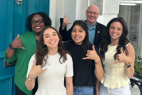 Associate Dean Natasha Randle, Dean Richard Buttimer, and Belk College students Erika Ayon, Karla Paulino, and Becca Sergel smile and make the “Pickaxe” hand sign outside the CEA CAPA London Center.